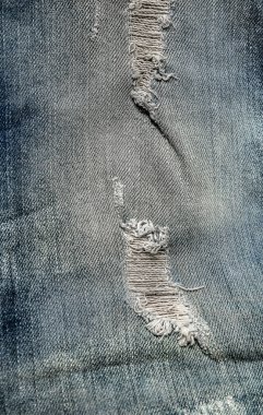 Denim Jeans'te delik. Yırtık Yırtık Yırtık Mavi kot arka plan. Mavi denim dokusunu kapatın