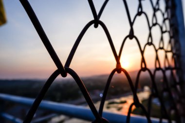 Gün batımı bulanıklığı arka plan ile Çit ızgaraları