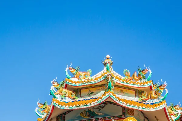 Chinese style dragon statue on china temple roof with blue sky