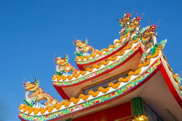 Chinese style dragon statue on china temple roof with blue sky