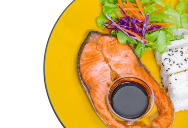 Izgara somon balık, pirinç, susam, salata ve teriyaki sos ahşap arka plan üzerinde sarı çanak