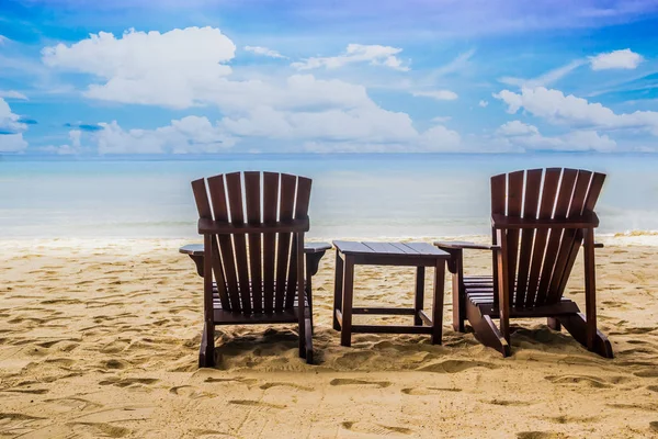 Sedie in legno sulla spiaggia di sabbia vicino al mare con una bella spiaggia tropicale — Foto Stock
