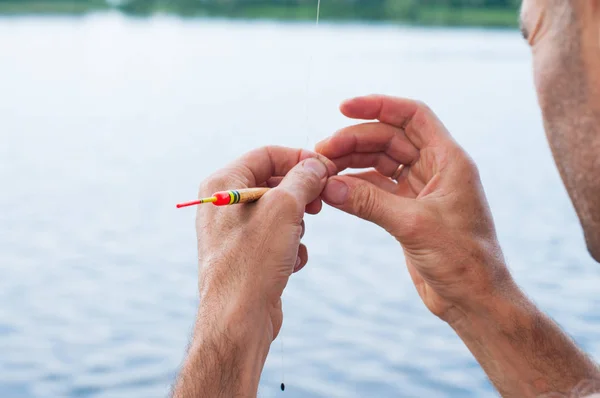 Man unraveling to the tangled and knotted Fishing line. Problem solving. — Stock Photo, Image