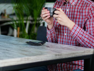 beyaz bir masada kahve içen adam
