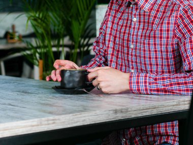 beyaz bir masada kahve içen adam