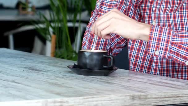 Hombre Está Sentado Café Con Una Taza Café Mezclándolo Cappuccino — Vídeo de stock