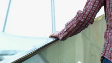 yürüyen merdiven hareket eden bir akıllı telefon ile adam. Yukarı çıkıyor. Görüntüleri kapat