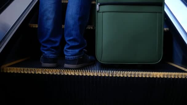 男はスーツケースの荷物を持ってエスカレーターに上がる クローズアップ — ストック動画