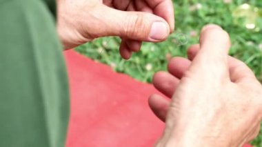 Adam karışık ve düğümlü balıkçılık hattı için çözülüyor. Sorun çözme.