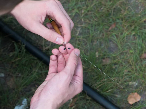 man clings to fishing line close up