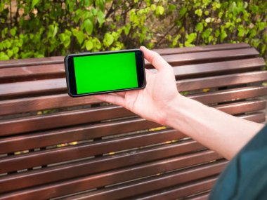 İnsan eli yeşil ekran ile mobil Smartphone gösterir