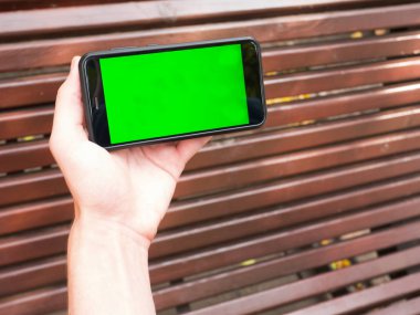 İnsan eli yeşil ekran ile mobil Smartphone gösterir