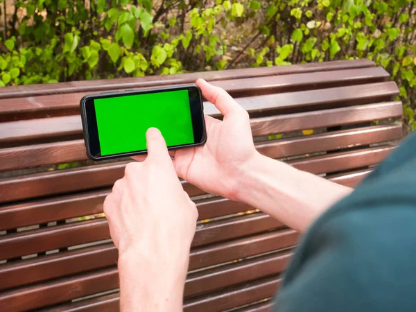 İnsan eli yeşil ekran ile mobil Smartphone gösterir