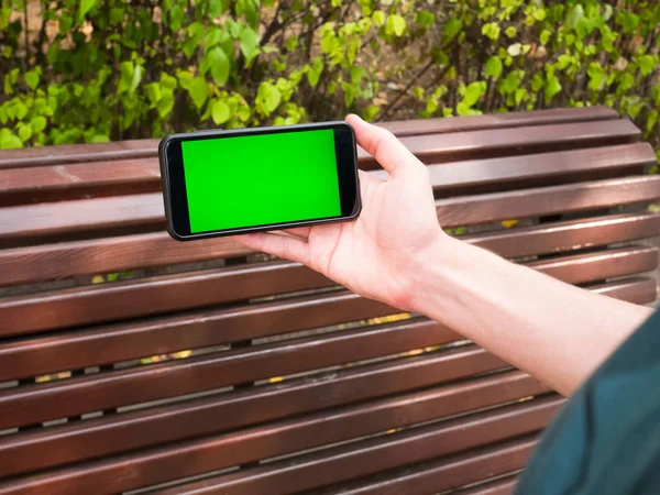 İnsan eli yeşil ekran ile mobil Smartphone gösterir