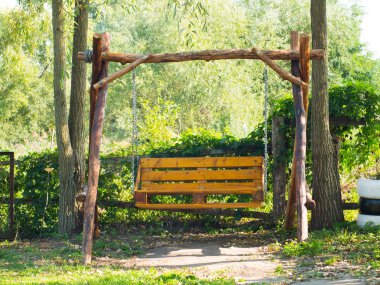 Yeşil bahçede tahta salıncak. Tezgah