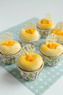 Yeşil arka plan üzerinde taze mango ve çikolata elemanları parçası ile dekore tropikal cupcakes seti