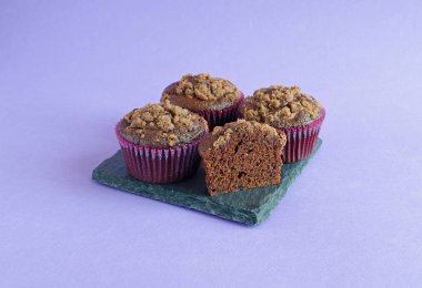 Mor arka plan üzerinde siyah kare tahta üzerinde çikolatalı muffins seti