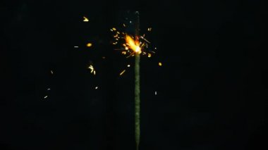 Bengal ışıklar. Bir sopa alanının o girerken Bengal ateşi bulunan dikey orta, bir turuncu parlamayı kadar ışıklar. Farklı yönlere ayrı kıvılcımlar. Siyah bir arka plan shooted.