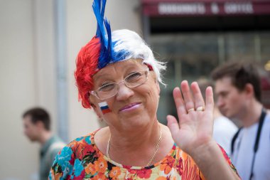 Moskova, Rusya - 23 Haziran 2018: eski Rus kadın spor fan yanak konuksever elini Rus bayrağı ile imzalamak, Moskova Nikolskaya sokakta futbol Dünya Şampiyonası sırasında.