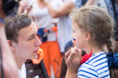 Moskova, Rusya - 23 Haziran 2018: adam çizim Rus bayrağı genç kızın yanağına fan Moskova Nikolskaya sokakta spor