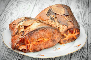 Laurel ve fesleğen ile pembe somon füme iki büyük parça yaprakları ahşap çerçevede bir plaka üzerinde.