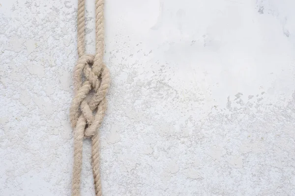 白のテクスチャ コンクリート背景 コピーの領域での平面図にロープの結び目 — ストック写真