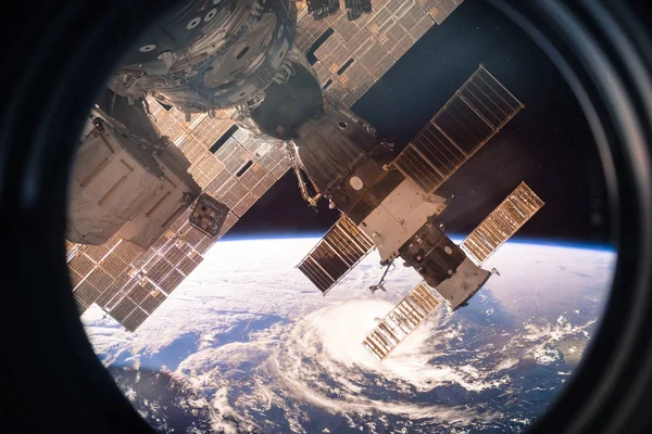 Image de collage avec la planète Terre depuis l'espace depuis la fenêtre de l'ISS. Un énorme ouragan. Éléments de cette image fournis par la NASA . — Photo