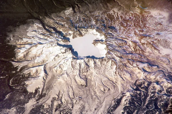 冬、衛星ビューで白頭山を眠っています。4.5 キロ直径 850 メートル深い山頂火山のカルデラ湖天池の水満ちています。Nasa から提供されたこのイメージの要素 — ストック写真