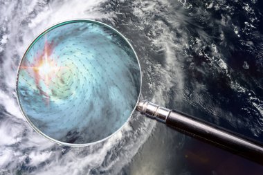 Hurricane and magnifying glass with wind speed direction scheme range of speeds and surface winds in zoomed area. Studying the weather concept. Elements of this image furnished by NASA. clipart