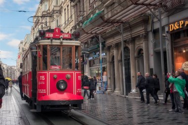 İstanbul, Türkiye - 14 Nisan 2019: İstiklal Caddesi üzerinde hareket eden kırmızı nostaljik tramvay. İstiklal Caddesi Beyoğlu, Taksim, İstanbul'un en popüler destinasyonudur.