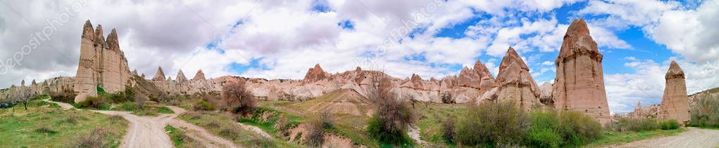 Panoramic view of the Love valley with huge phallus shape stones in Goreme village, Turkey. Rural Cappadocia landscape. Volcanic mountains in Goreme national park. Countryside lifestyle.
