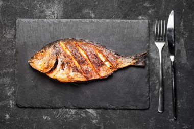 Izgara dorada sadece siyah bir taş tepsi üst görünümünde.