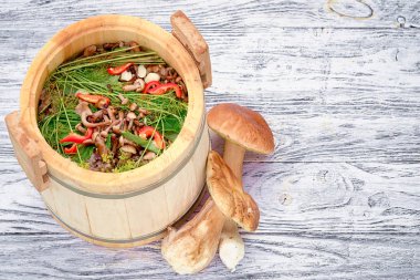 Ahşap bir varil içinde bal agarik mantar salting, ve iki boletus. Metniniz için kopya alanı ile üst görünüm.