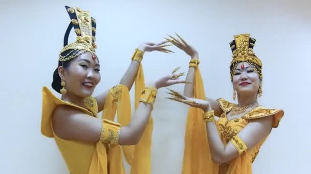 两个美丽的亚洲妇女跳舞与手与长指甲美甲在传统的泰国黄色礼服 — 图库视频影像