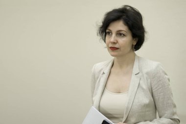 Başarılı bir özgüven portresi. Orta yaşlı, iş elbiseli, fotokopi alanı olan bir iş kadını..