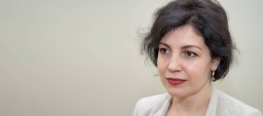 Çekici orta yaşlı başarılı kadınlar iş elbisesinde güzel bir gülümsemeyle beton bej duvara karşı, kafasında ve omuzlarında fotokopi alanı olan portreler..