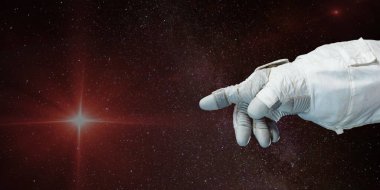 Astronot eli uzayın derinliklerindeki yıldızı işaret ediyor. Bu görüntünün elementleri NASA tarafından desteklenmektedir.