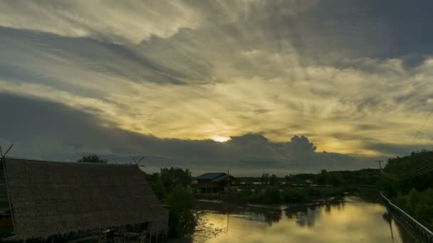 Timelapse zonsondergang achter een bewegende wolk. Geeft een mooi goudkleurig licht boven de moerassen. — Stockvideo