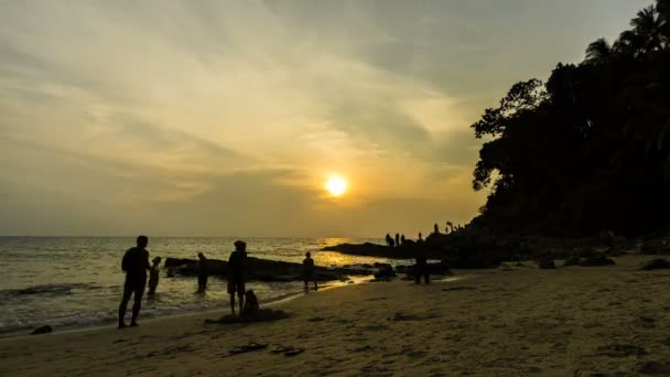 Tevékenységek a tengerparton a Surin Beach, Phuket. Tam lap, naplemente idő. Narancs ég, felhős égbolt — Stock videók