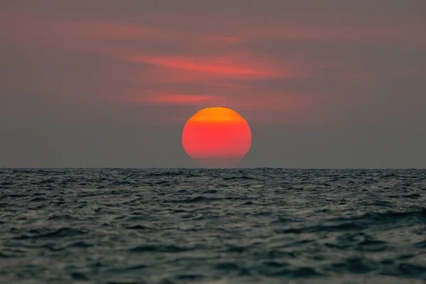 The sun is falling into the sea, the bottom of the sun eccentric — Stock Photo, Image
