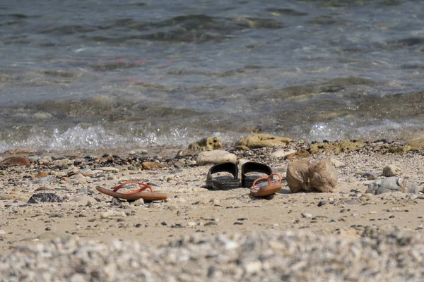 Os viajantes tiram sapatos casuais na praia junto ao mar para nadar . — Fotografia de Stock