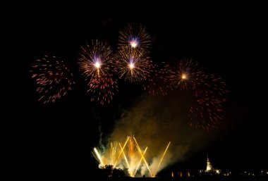 Gün batımında pirinç tarlaları üzerinde büyük, renkli havai fişek.