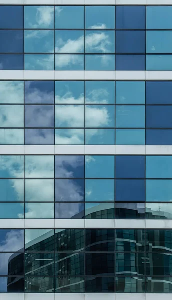 Fachada de construção de vidro azul com reflexão do céu — Fotografia de Stock