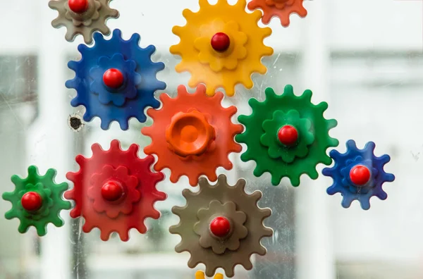 connecting colorful plastic gear wheels isolated on white background