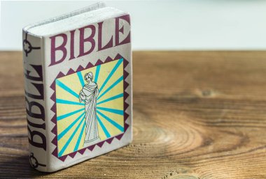ahşap masa üzerinde plastik bir İncil oyuncak kitap ekran