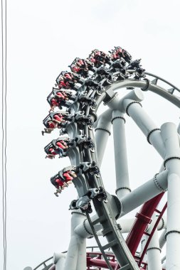 Singapur-26 Eyl 2017: İnsanlar gri gökyüzünde roller coaster keyfini