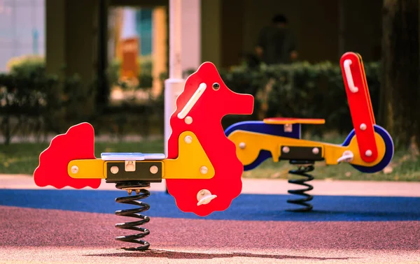 Rotes Schaukelpferd für Kinder auf einem Kinderspielplatz — Stockfoto