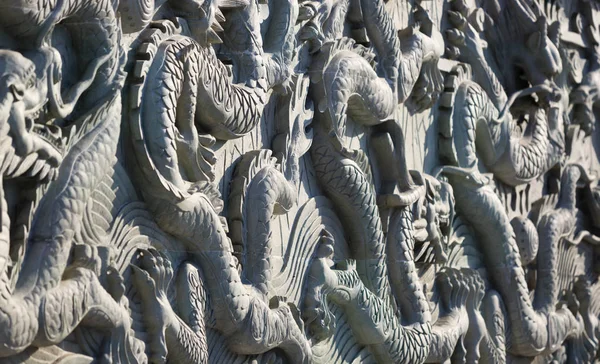 Eine weiße Wand mit Drachenstein-Skulptur Hintergrund — Stockfoto