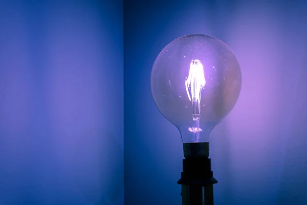 Forma redonda Bombilla sobre fondo azul — Foto de Stock