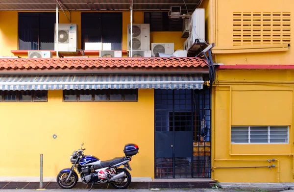 Singapore-24 Mar 2018: Motorcykel framför bostadshus i Singapore traditionellt område — Stockfoto